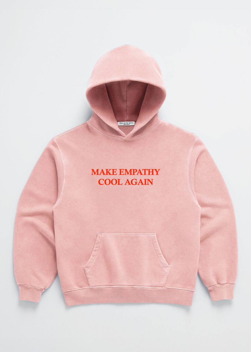 A pink hoodie with the text 'MAKE EMPATHY COOL AGAIN' printed in red on the front center chest area.